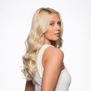 Side view of 20” one piece curly clip-in hair extension worn by pretty blonde girl